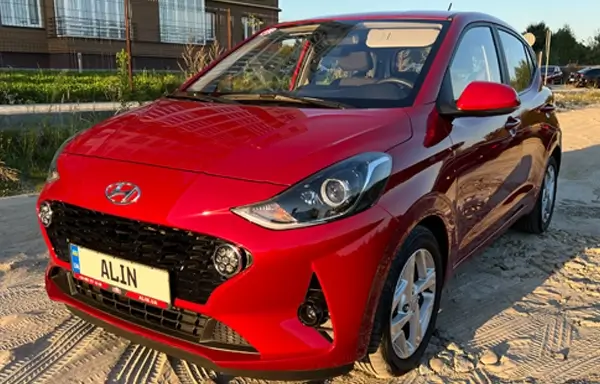 A red Hyundai i10 on a city street. Its compact and modern design is perfect for urban driving.